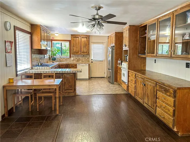 a kitchen with stainless steel appliances a table chairs and a refrigerator