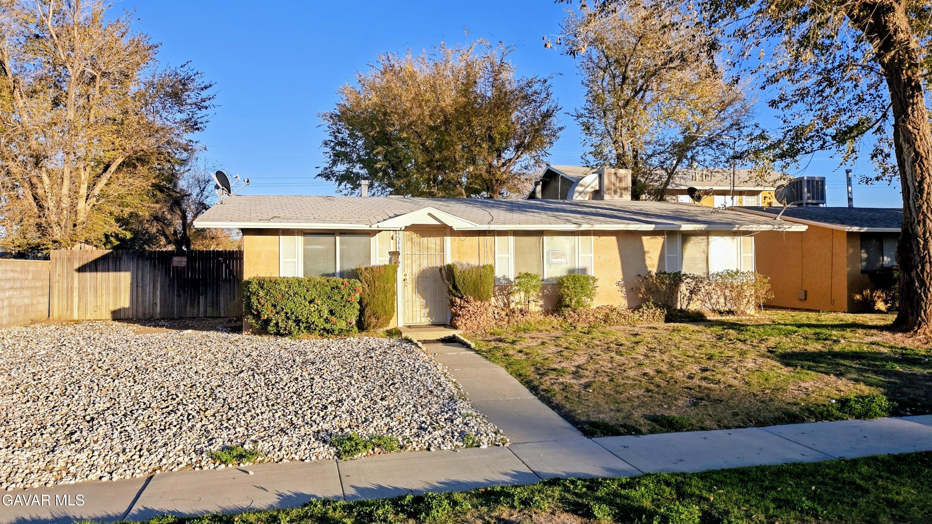 a view of a house with large trees in front of it