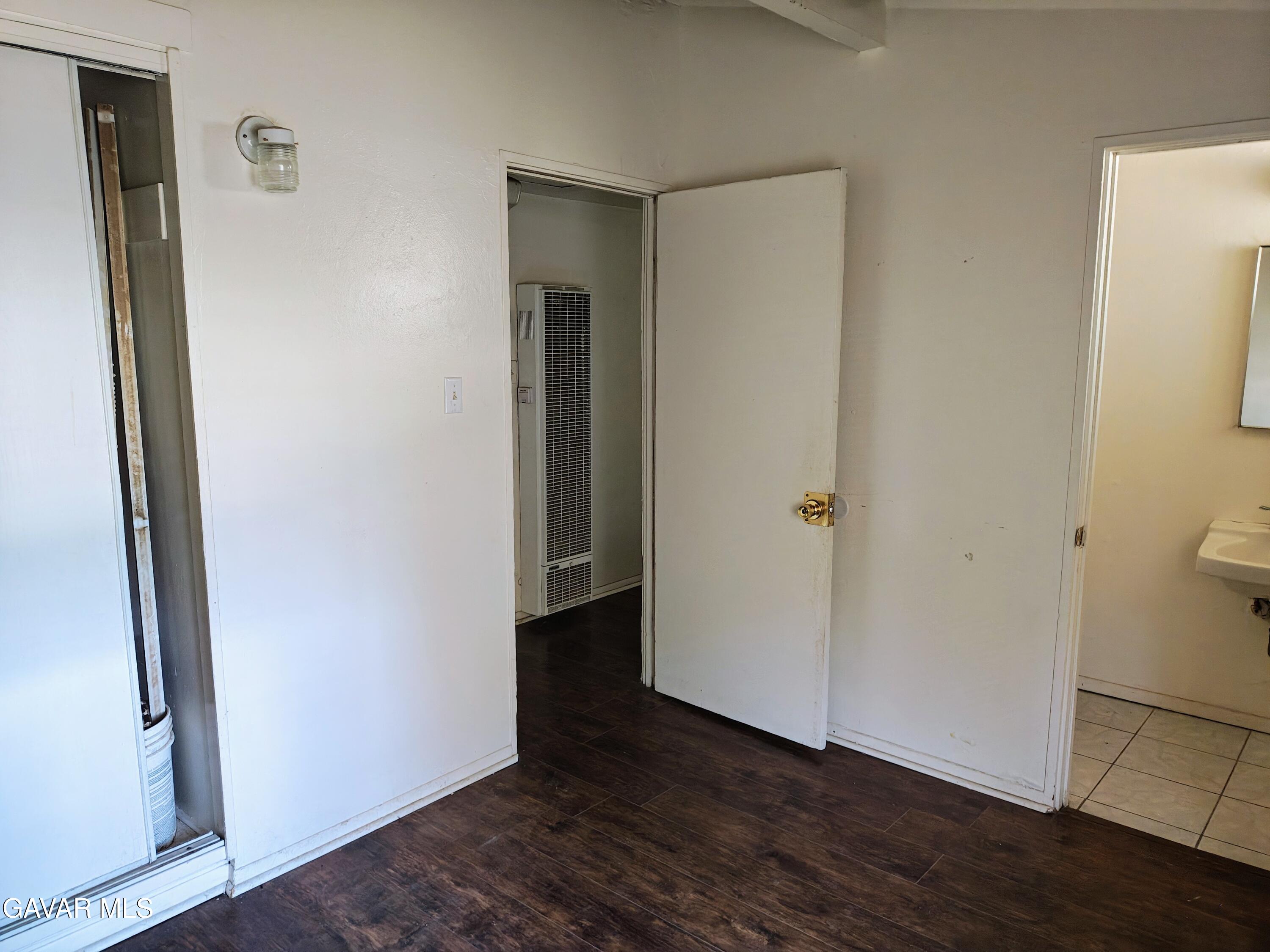 45446 10th Street West Lancaster, CA 93534 - Photo 12 of 17 a view of an empty room with wooden floor and a bathroom