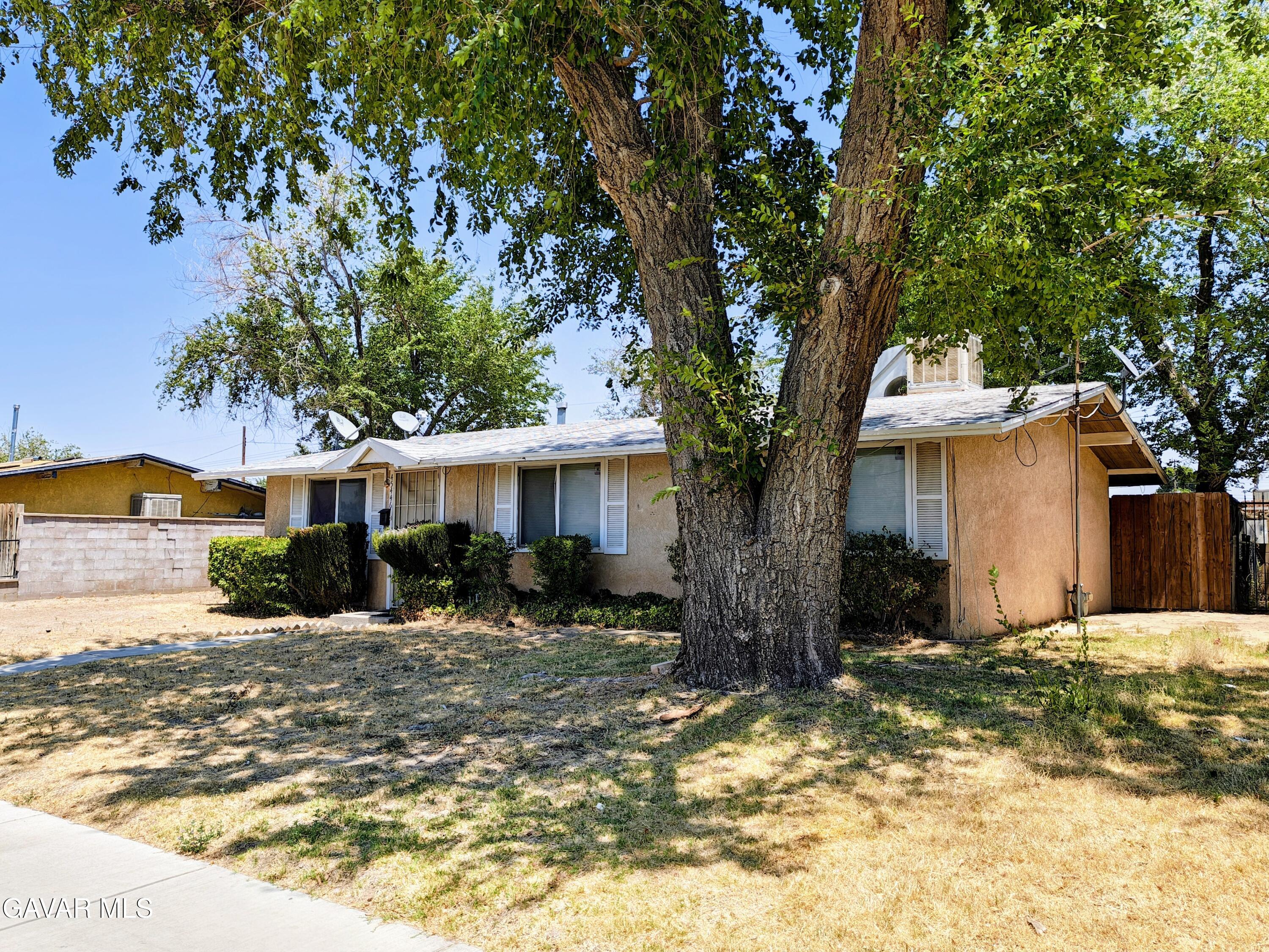45446 10th Street West Lancaster, CA 93534 - Photo 3 of 17 a front view of a house with a yard and garage