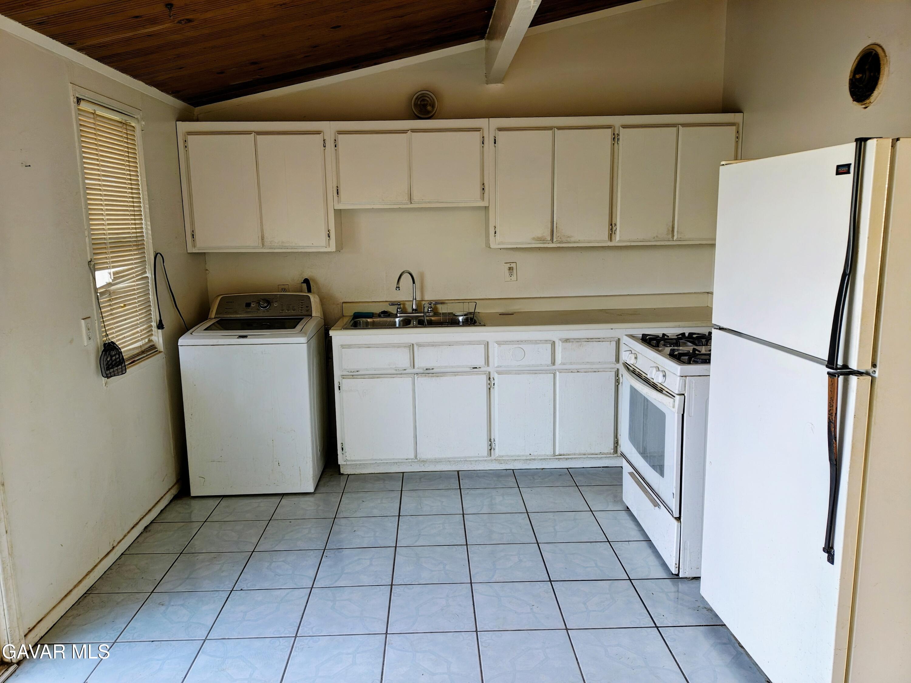 45446 10th Street West Lancaster, CA 93534 - Photo 4 of 17 a kitchen with a sink a refrigerator and cabinets