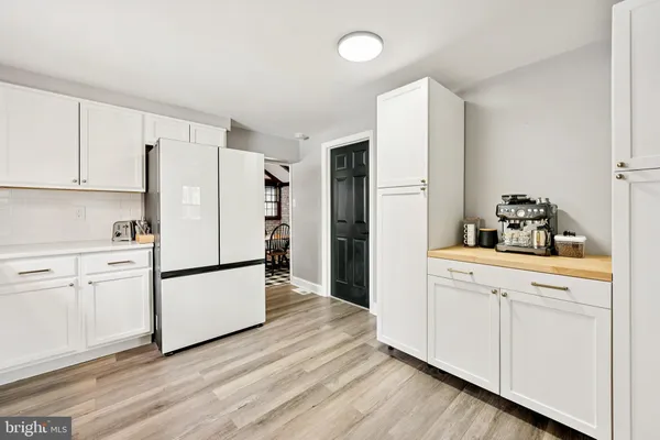 a kitchen with white cabinets and white appliances