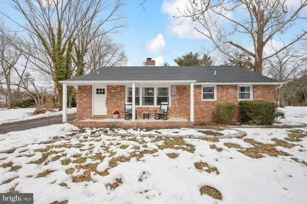 a front view of a house with a yard covered in snow