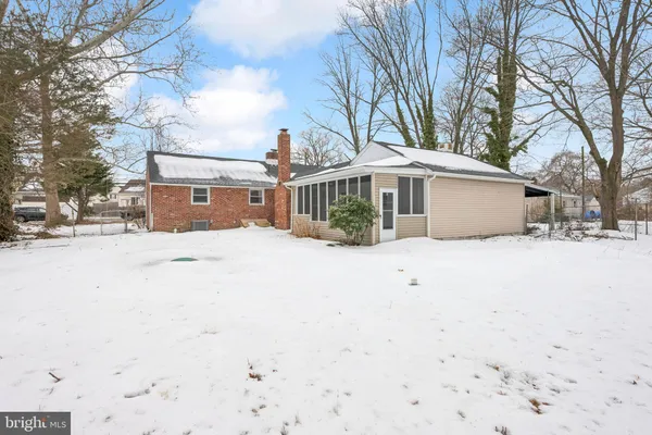 a front view of a house with a yard covered with snow