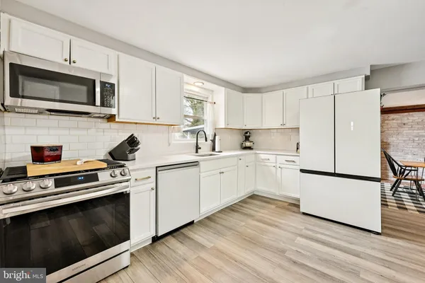 a kitchen with white cabinets stainless steel appliances and sink