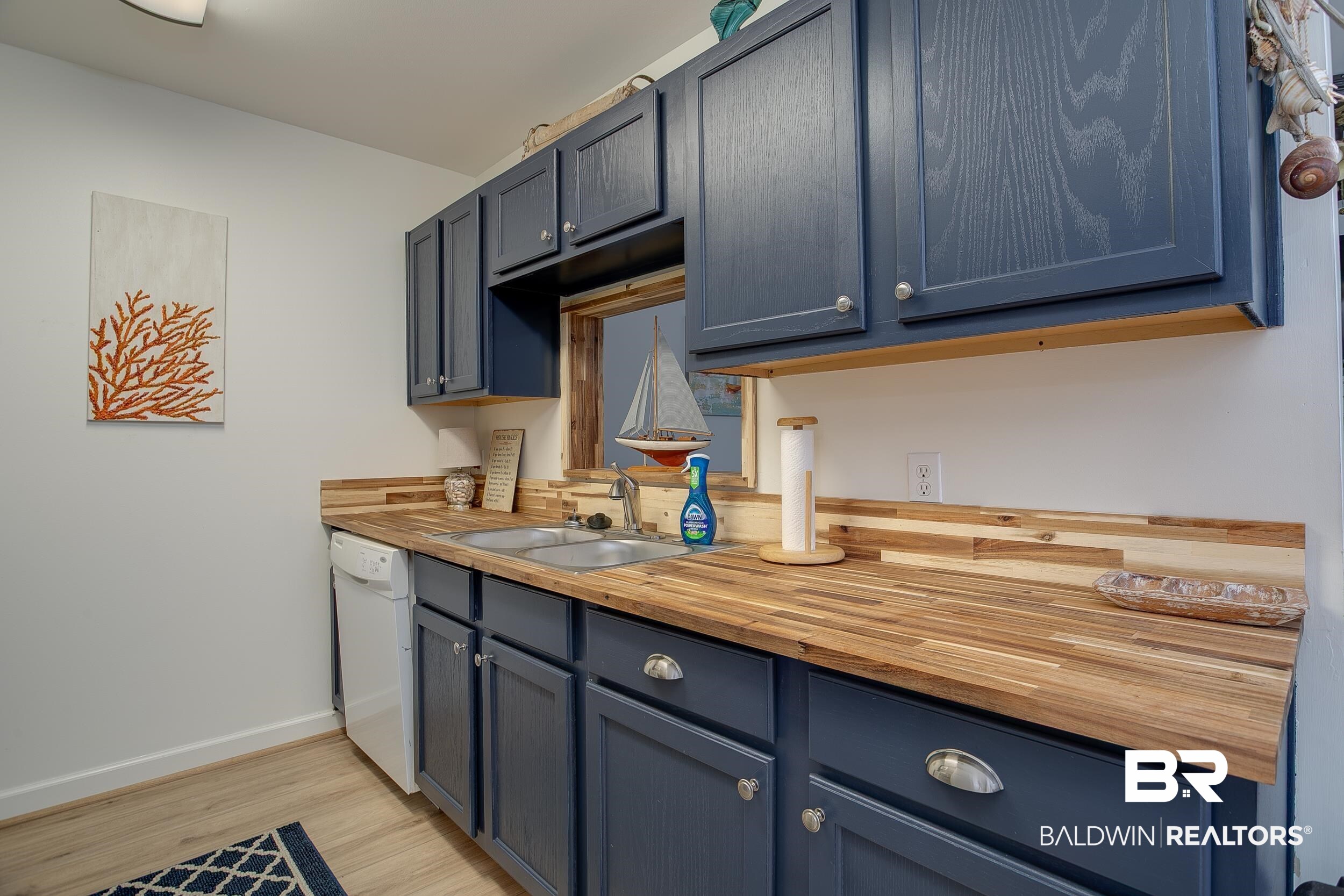 1517 Regency Road, Unit 33 Gulf Shores, AL 36542 - Photo 3 of 29 Kitchen with dishwasher, blue cabinets, a sink, and butcher block counters