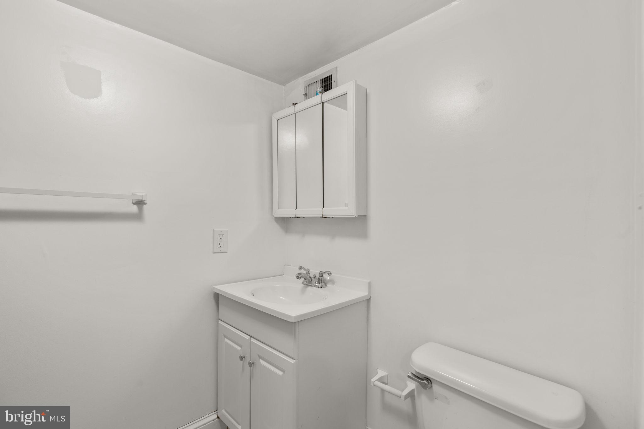 1456 Battery Avenue Baltimore, MD 21230 - Photo 24 of 31 a bathroom with a sink a toilet and mirror