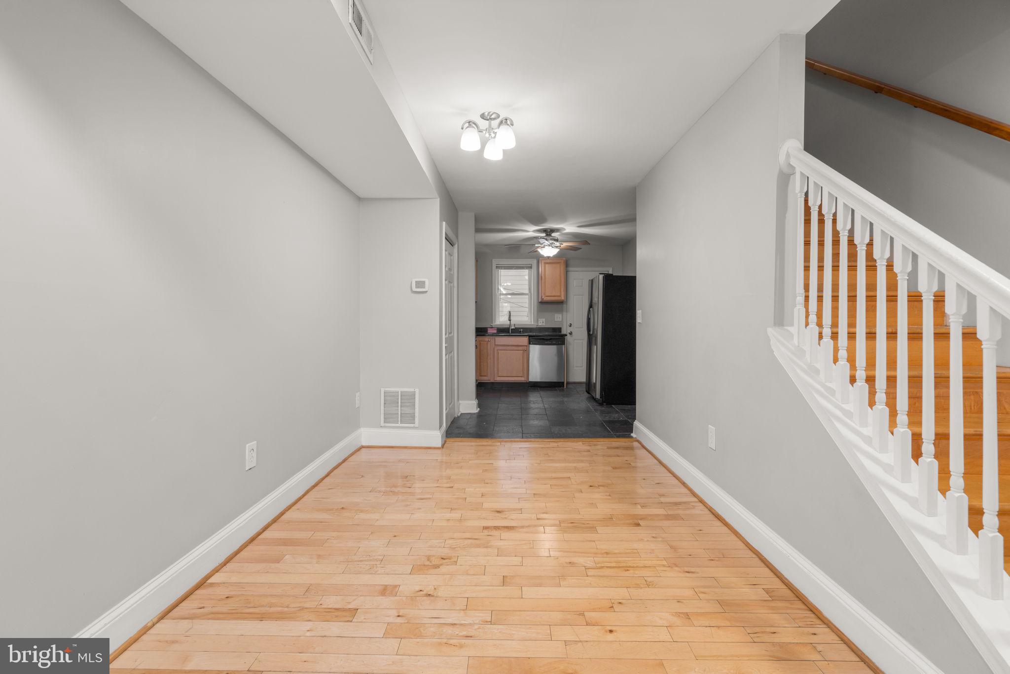 1456 Battery Avenue Baltimore, MD 21230 - Photo 6 of 31 a view of a hallway with wooden floor and a kitchen space