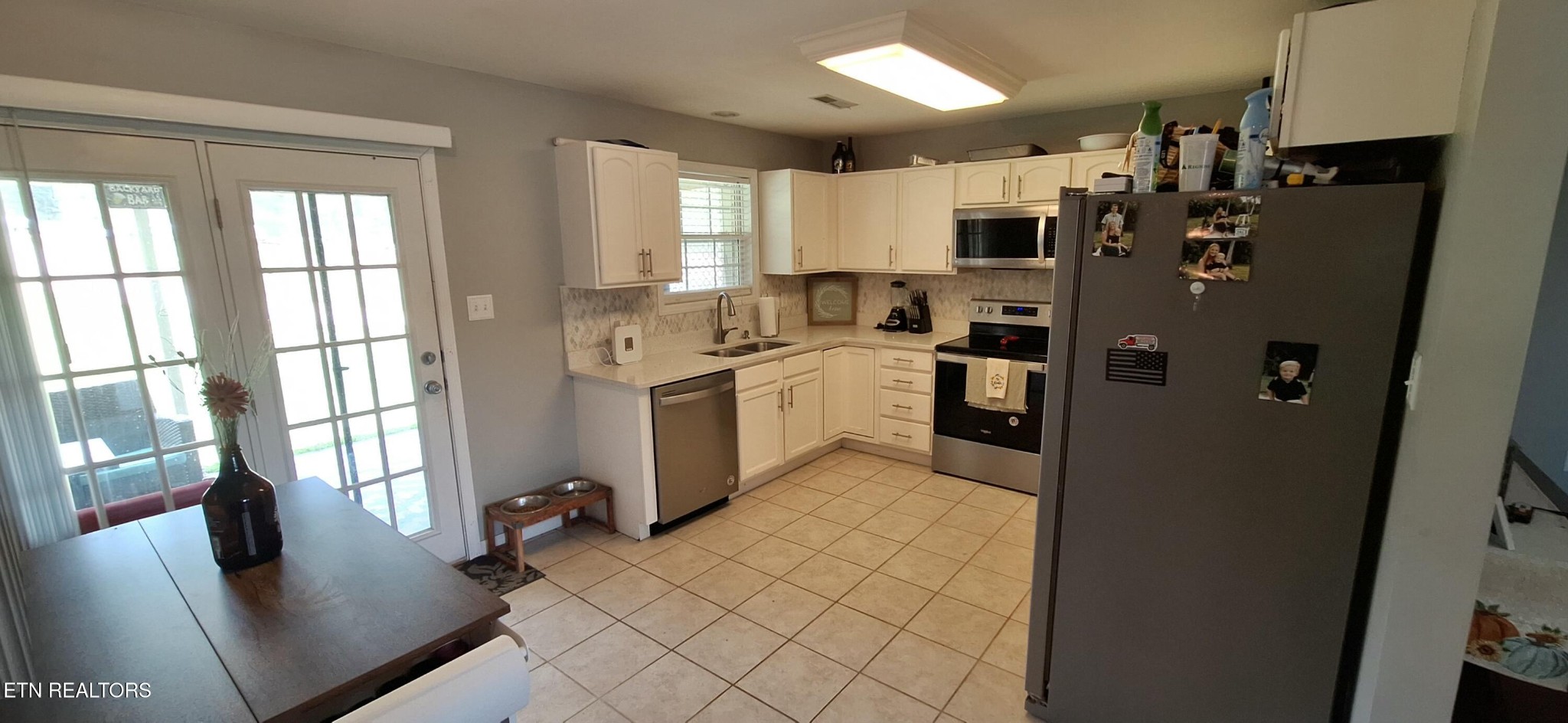 6199 Sinking Creek Road Greenback, TN 37742 - Photo 32 of 33 a kitchen with stainless steel appliances granite countertop a refrigerator a stove a sink dishwasher and white cabinets with wooden floor