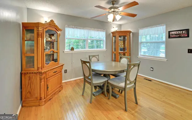 a dining room with furniture a chandelier and wooden floor