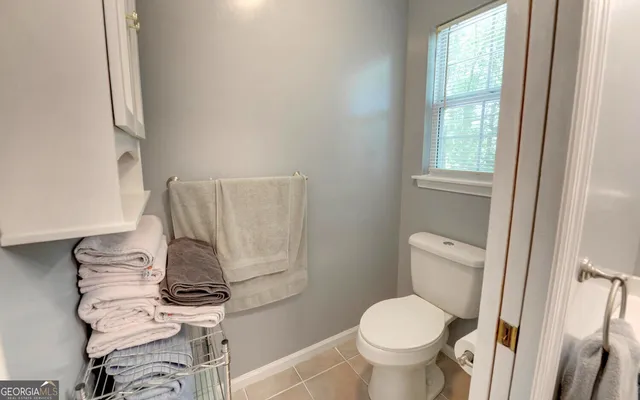 a white toilet sitting next to a window and a sink