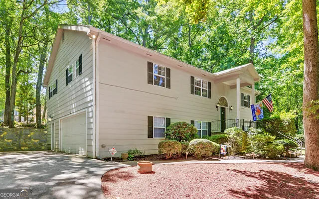 a front view of a house with a yard and potted plants