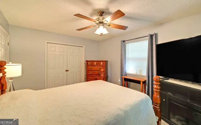 a bedroom with a bed and a flat screen tv