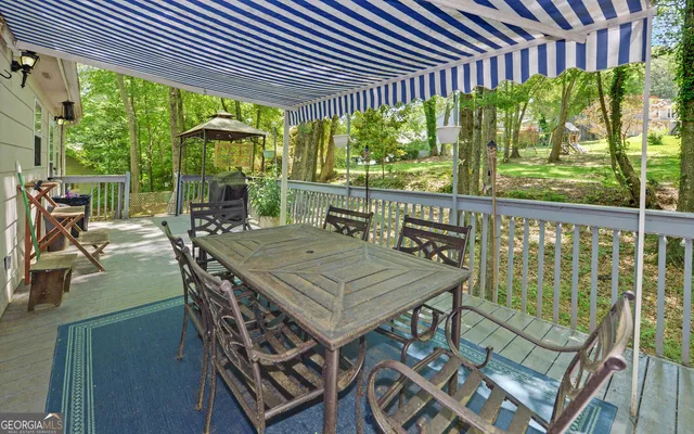 a view of a patio with table and chairs potted plants and floor to ceiling window