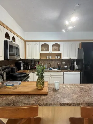 a kitchen with sink stove and microwave