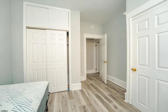 a view of a bedroom with wooden floor and a bathroom