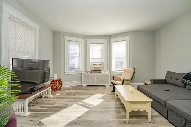 a bedroom with a bed and large windows