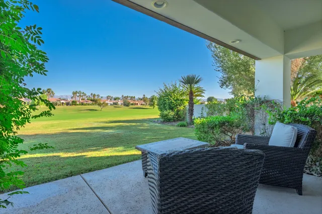 a view of a swimming pool and lounge chairs in back yard of the house