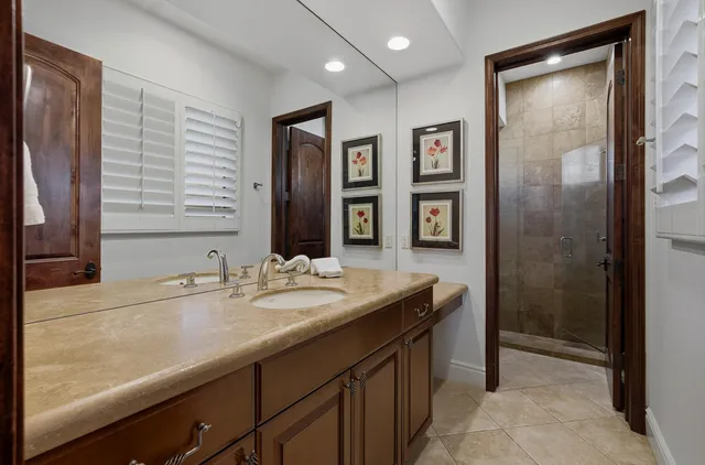 a bathroom with a granite countertop sink and a mirror