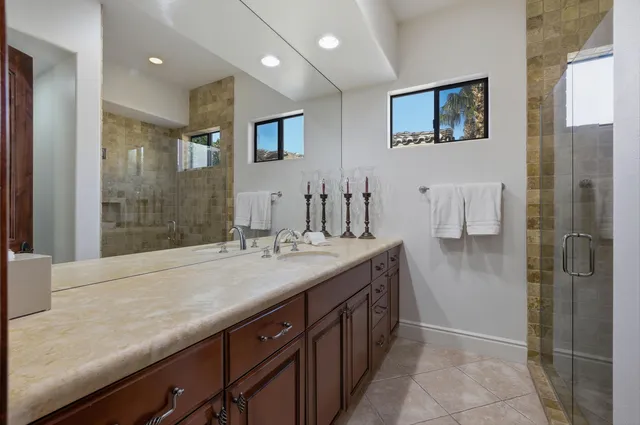 a bathroom with a granite countertop sink a shower and a mirror
