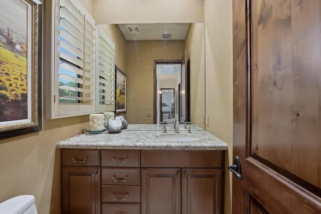 a bathroom with a granite countertop sink and a mirror