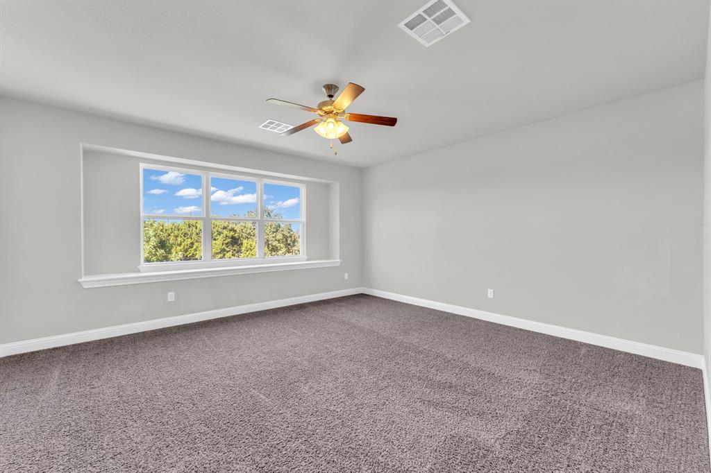 110 Magona Trail Georgetown, TX 78628 - Photo 19 of 38 Well-lit living area features neutral carpeting and an inviting window seat, ready for personalization.