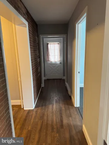 a view of a hallway with wooden floor and stairs