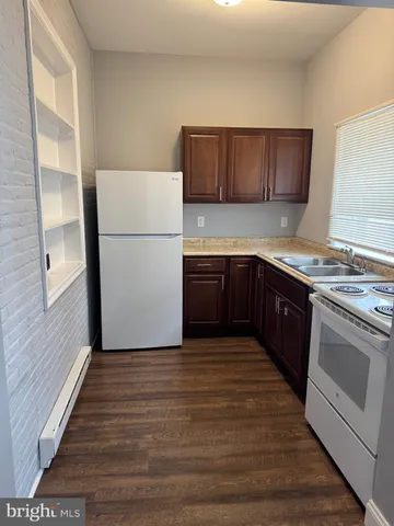 a kitchen with wooden cabinets and white appliances