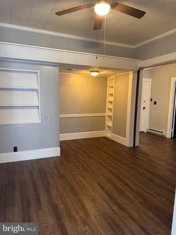 a view of empty room with wooden floor
