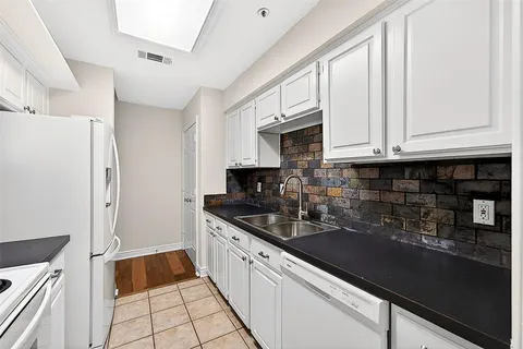 a kitchen with granite countertop white cabinets and black appliances