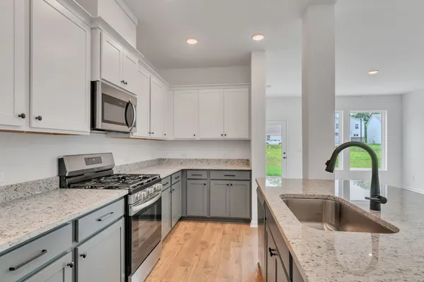 a kitchen with stainless steel appliances granite countertop a sink stove and cabinets