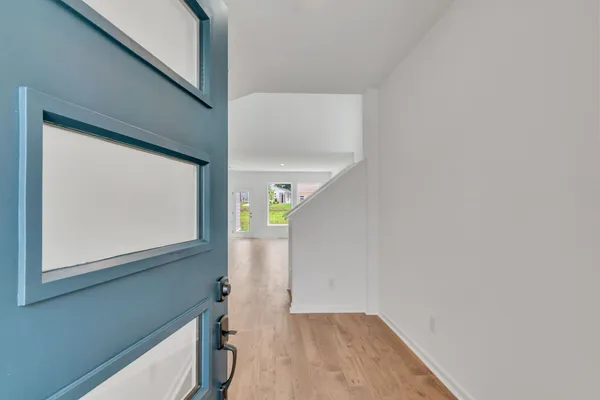 a view of hallway with a window and wooden floor