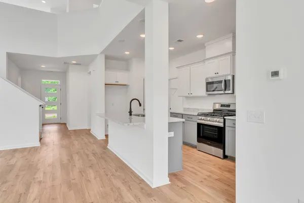 a large kitchen with stainless steel appliances granite countertop a stove a sink and a refrigerator