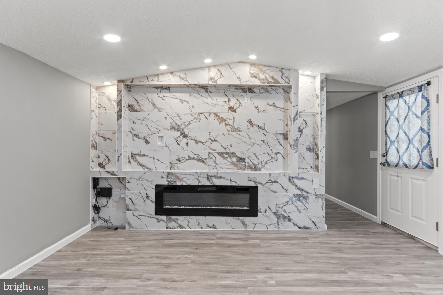 92 Patuxent Mobile Estates Lothian, MD 20711 - Photo 11 of 19 a view of empty room with wooden floor and fireplace