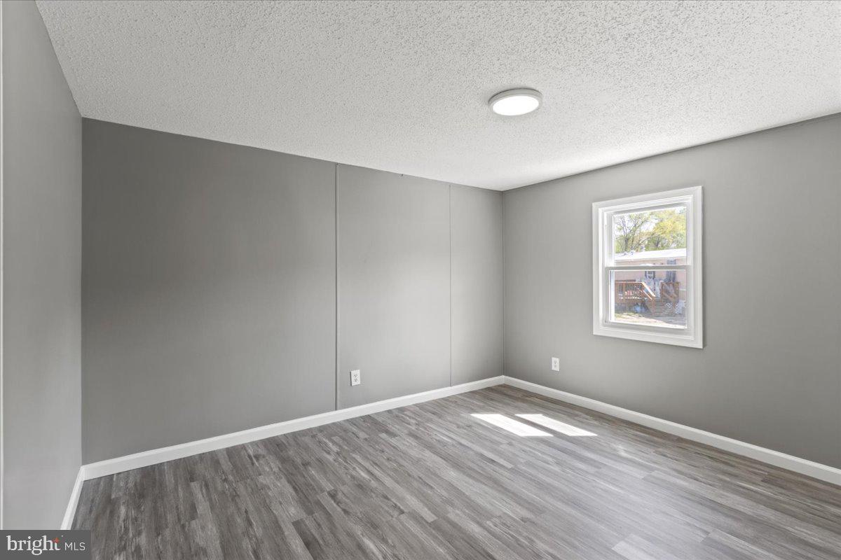 92 Patuxent Mobile Estates Lothian, MD 20711 - Photo 14 of 19 an empty room with wooden floor and windows