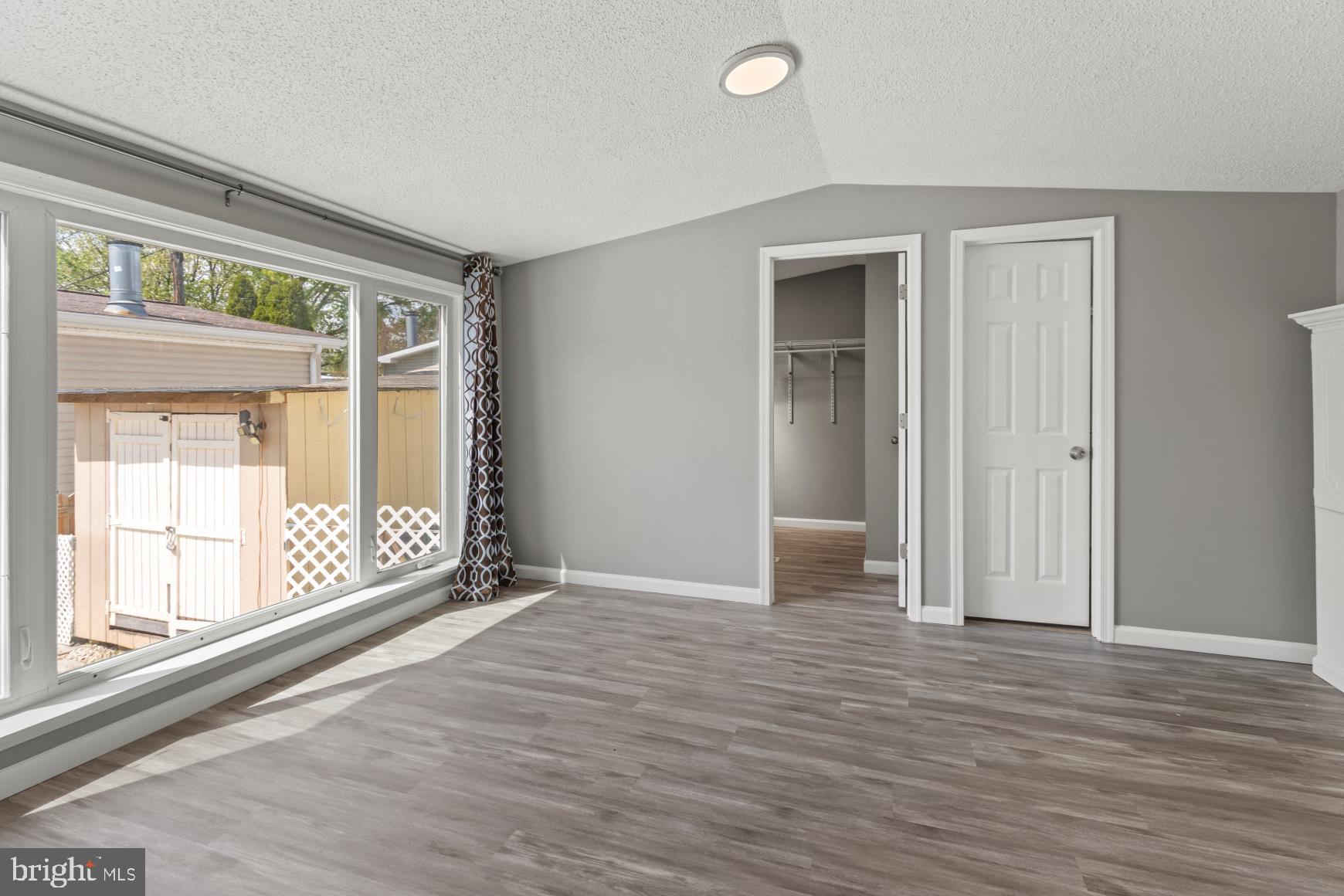92 Patuxent Mobile Estates Lothian, MD 20711 - Photo 5 of 19 a view of an empty room with wooden floor and a window