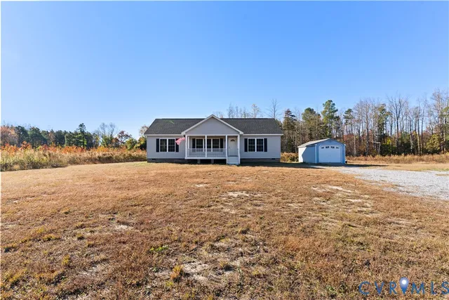 a front view of house with yard and trees in the background