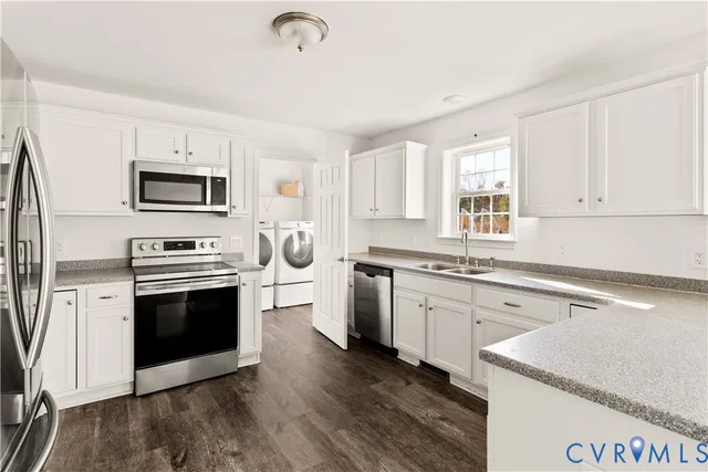 a kitchen with granite countertop a stove top oven sink and microwave