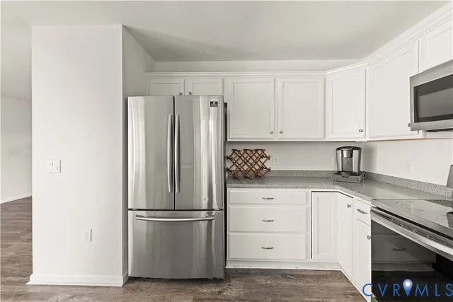 a kitchen with stainless steel appliances white cabinets and a refrigerator