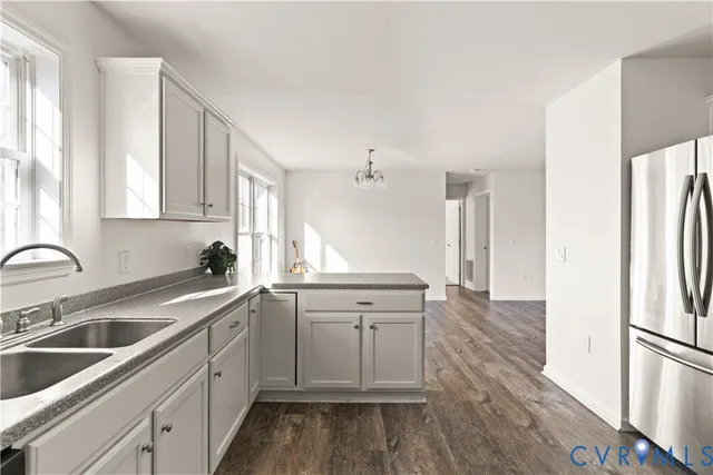 a kitchen with a sink cabinets stainless steel appliances and windows