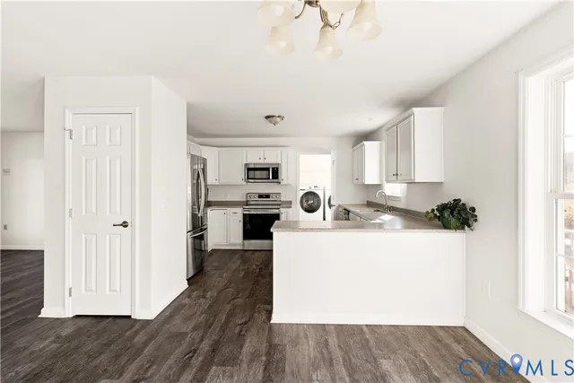 a large white kitchen with wooden floor