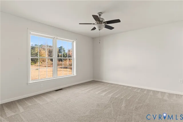an empty room with windows and fan