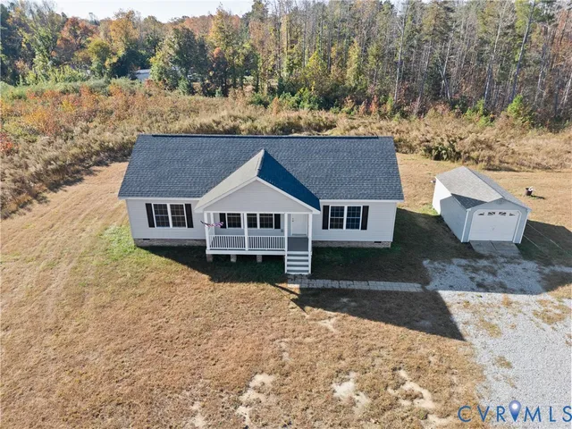 a aerial view of a house next to a yard with large trees