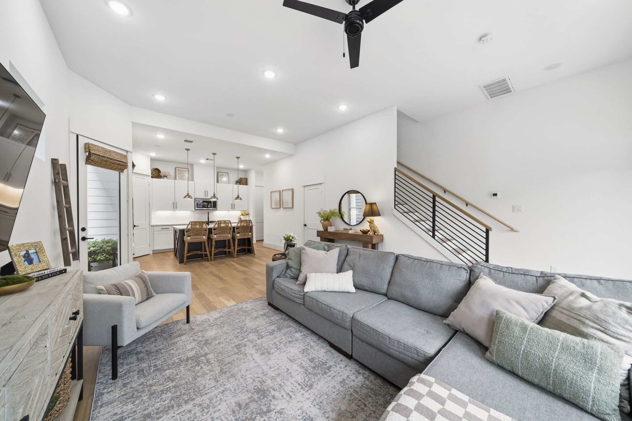 9018 Wellspring Drive Houston, TX 77080 - Photo 5 of 25 This wide-angle view illustrates the effortless flow between the airy living room and the gourmet kitchen, highlighting the soaring ceilings, custom banister, and the abundance of recessed lighting throughout the main floor.