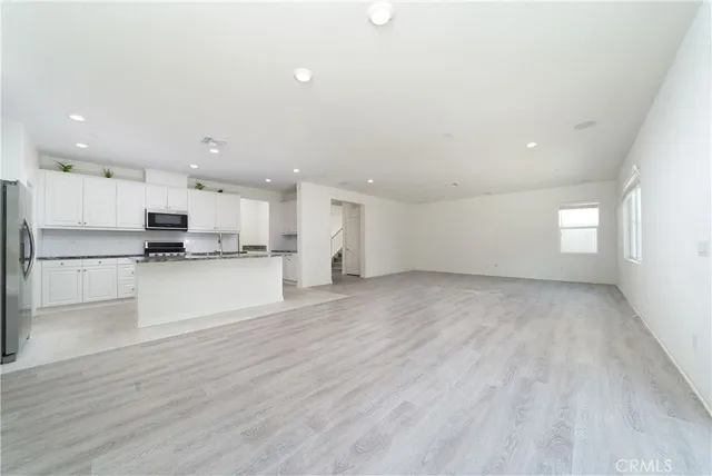 a view of kitchen view wooden floor stainless steel appliances and cabinets