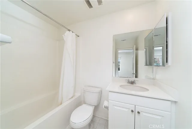 a bathroom with a toilet a sink a mirror a bathtub and vanity