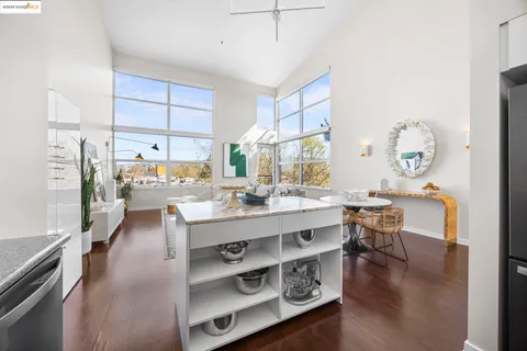 a kitchen with stainless steel appliances granite countertop a stove a sink dishwasher and a microwave oven with wooden cabinets