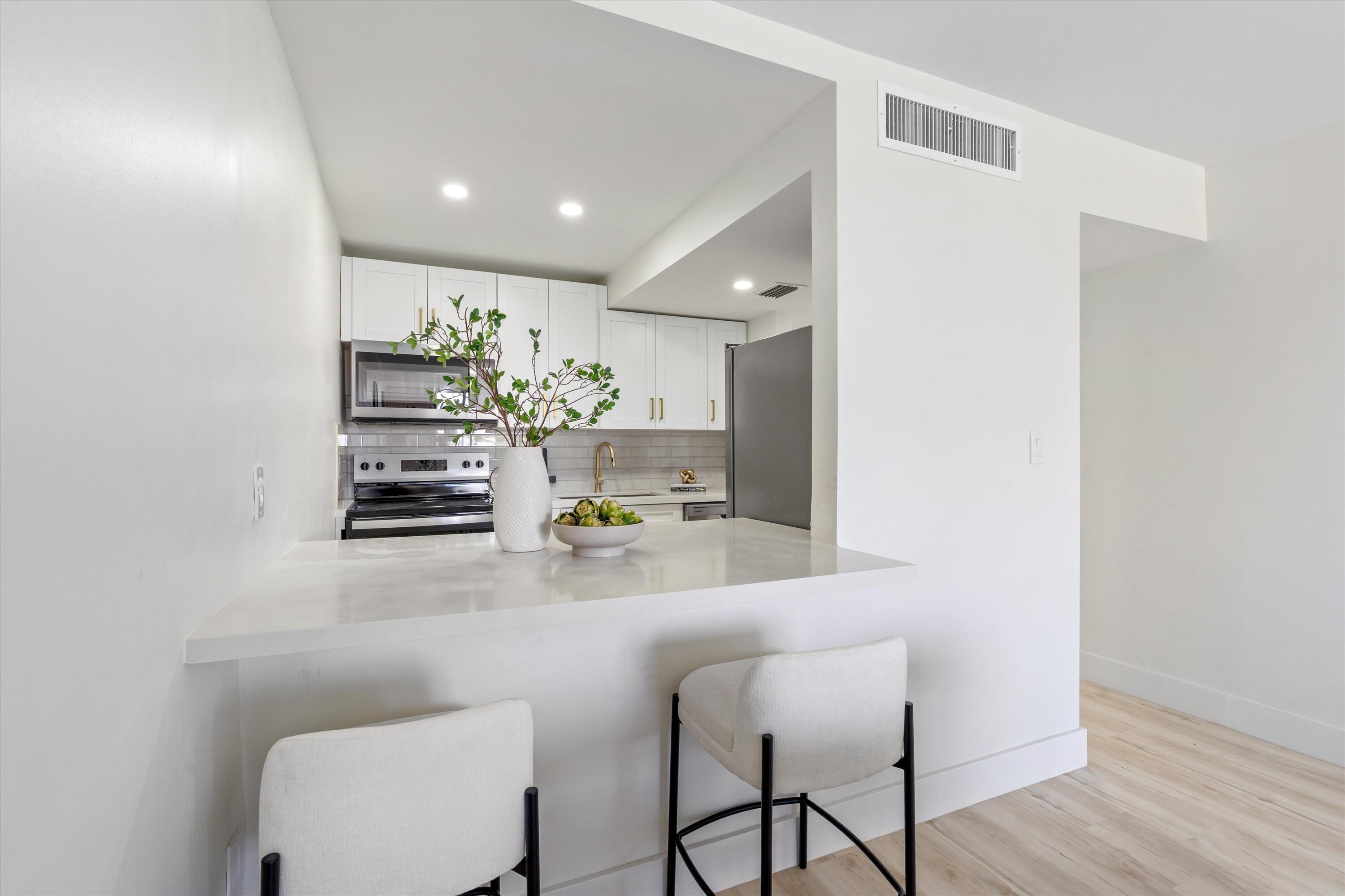 755 Dotterel Road, Unit 1307 Delray Beach, FL 33444 - Photo 6 of 36 a kitchen with appliances cabinets and chair
