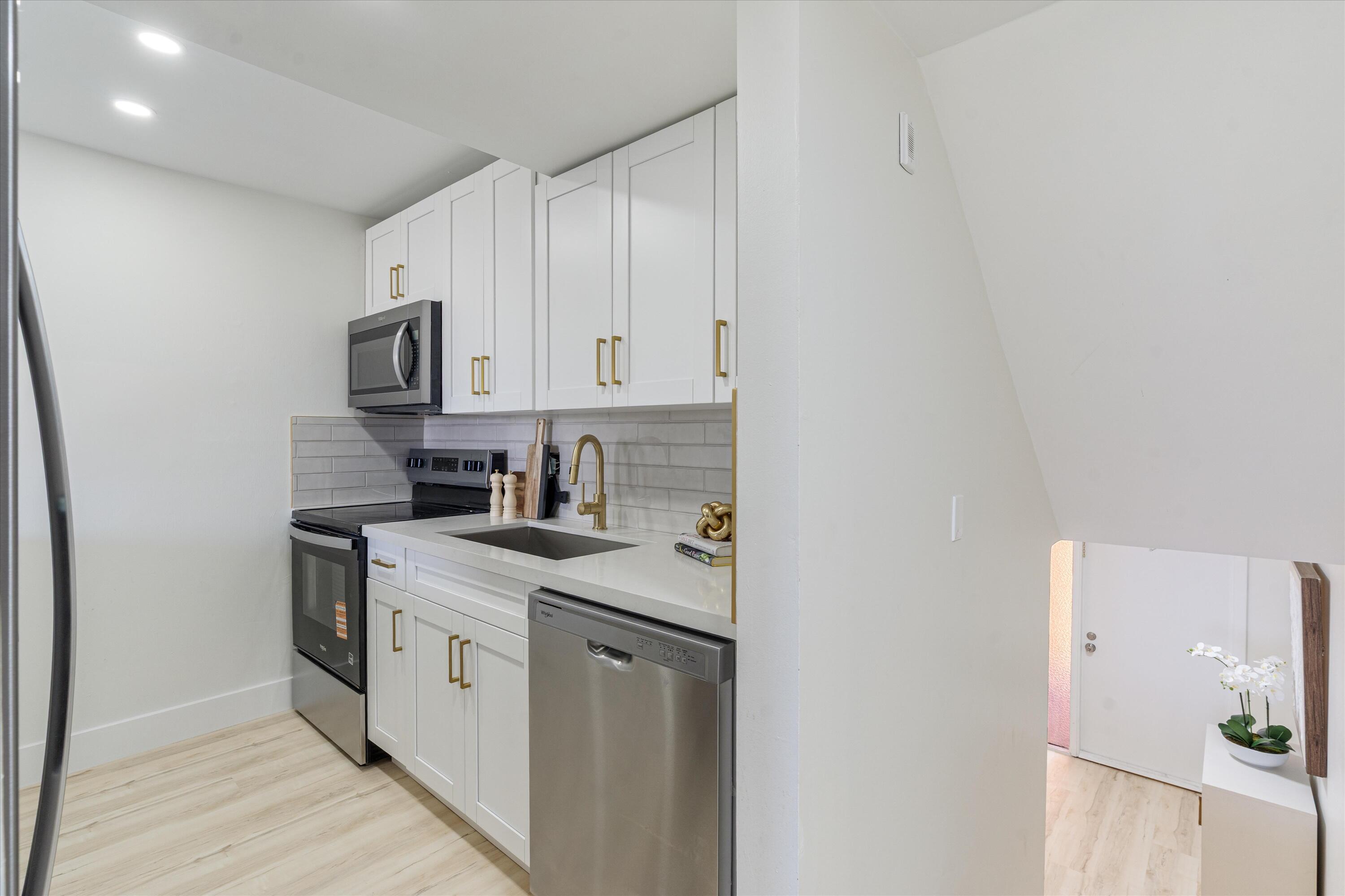 755 Dotterel Road, Unit 1307 Delray Beach, FL 33444 - Photo 8 of 36 a kitchen with stainless steel appliances granite countertop a sink stove and refrigerator