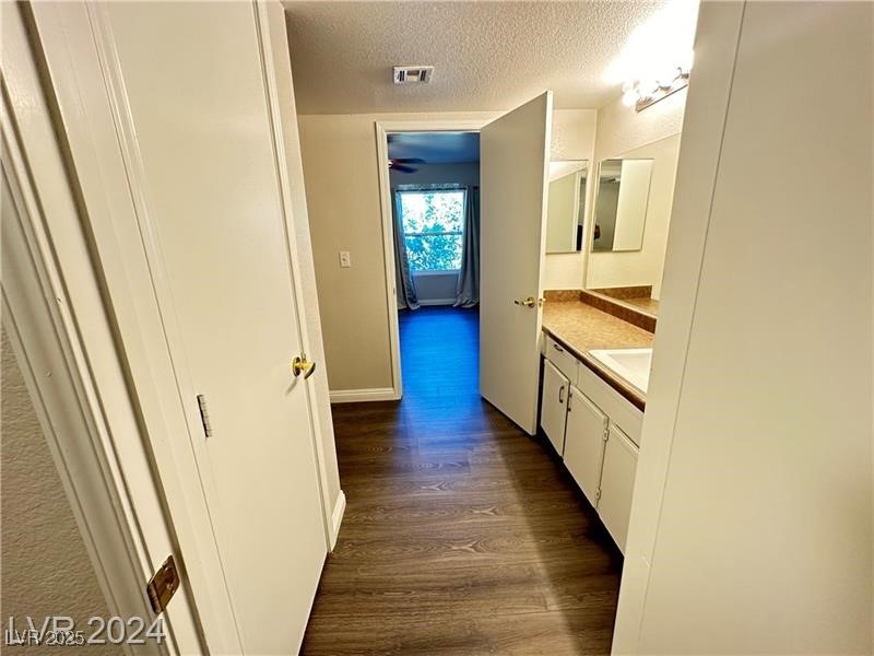 6650 West Warm Springs Road, Unit 2007 Las Vegas, NV 89118 - Photo 18 of 26 Bathroom featuring vanity, dark wood-style flooring, and a textured ceiling